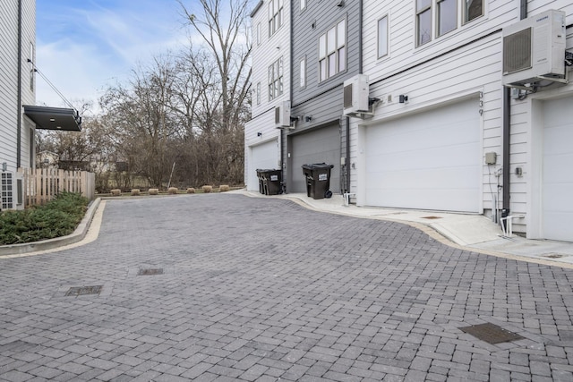 view of property exterior featuring a garage and ac unit