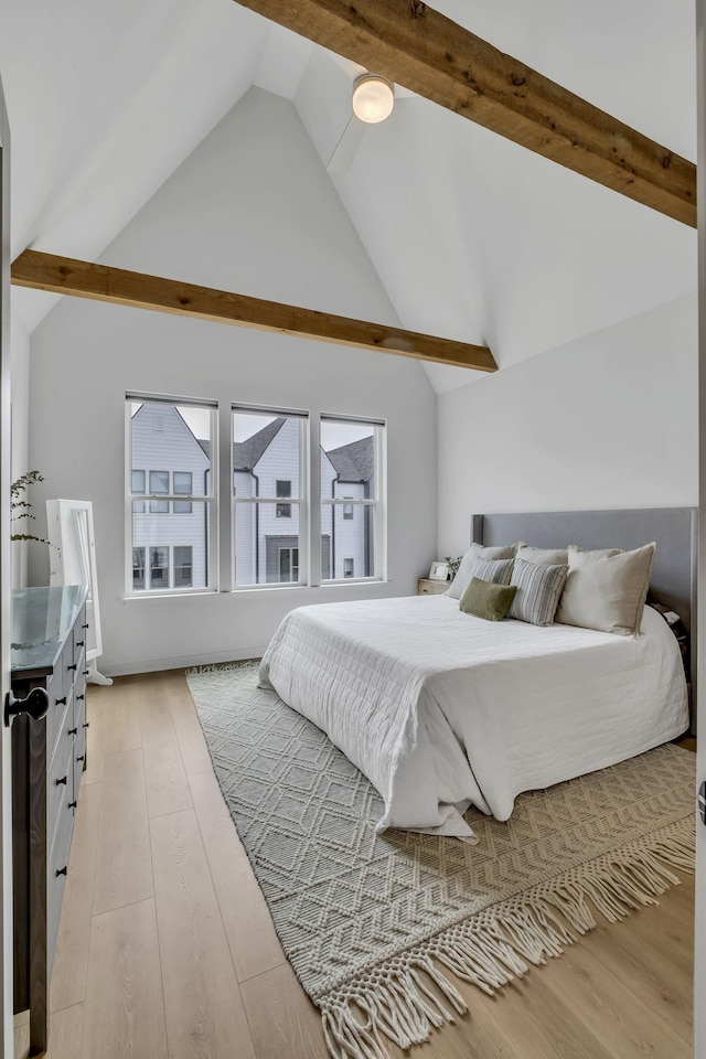 bedroom with beamed ceiling, high vaulted ceiling, and light hardwood / wood-style floors