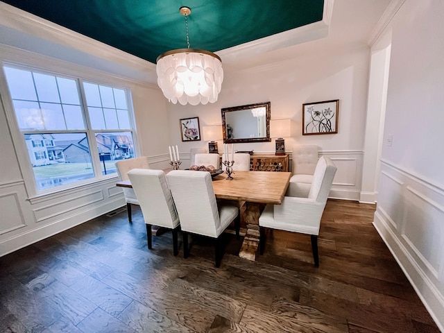 dining space with an inviting chandelier, dark hardwood / wood-style flooring, a raised ceiling, and crown molding