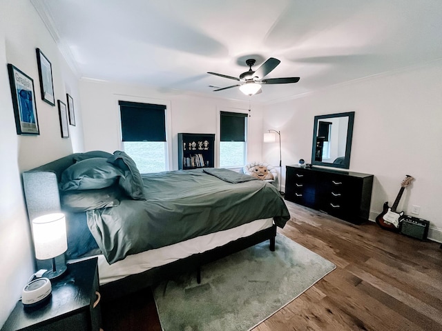 bedroom featuring dark wood-type flooring, ceiling fan, and crown molding