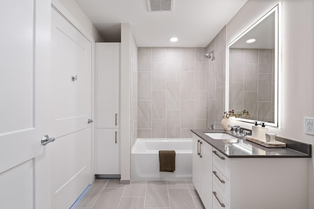 bathroom featuring tiled shower / bath, vanity, and tile patterned floors