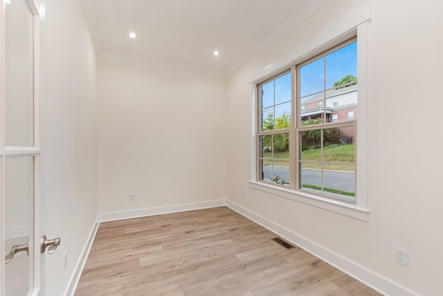 unfurnished room featuring ornamental molding and light hardwood / wood-style floors