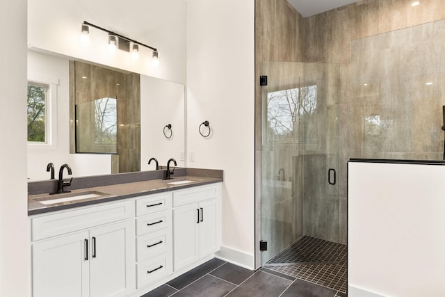 bathroom with a shower with door, vanity, and tile patterned flooring