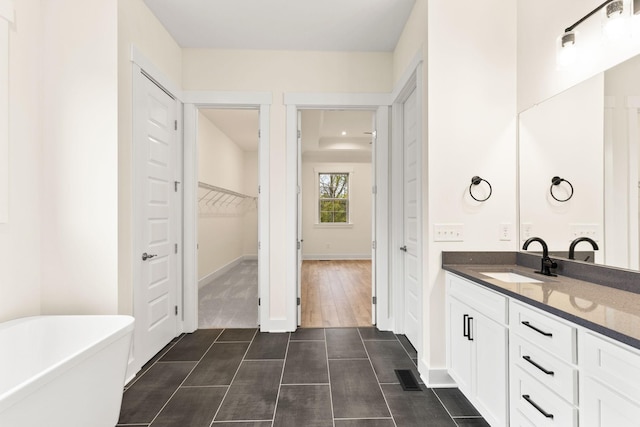 bathroom with tile patterned flooring, vanity, and a tub to relax in