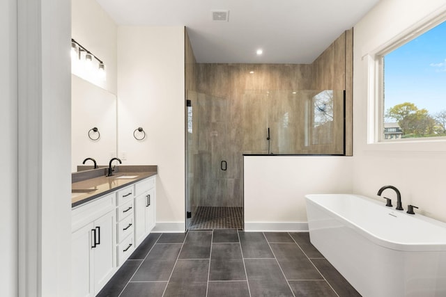 bathroom featuring vanity, tile patterned flooring, and plus walk in shower