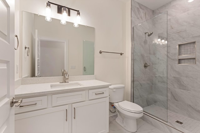 bathroom with vanity, toilet, and tiled shower