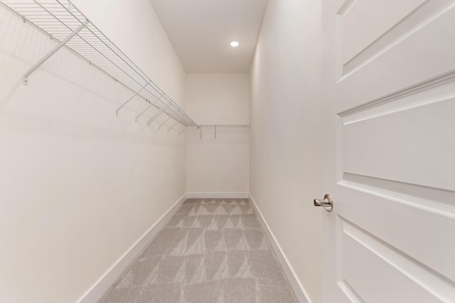 spacious closet featuring light colored carpet