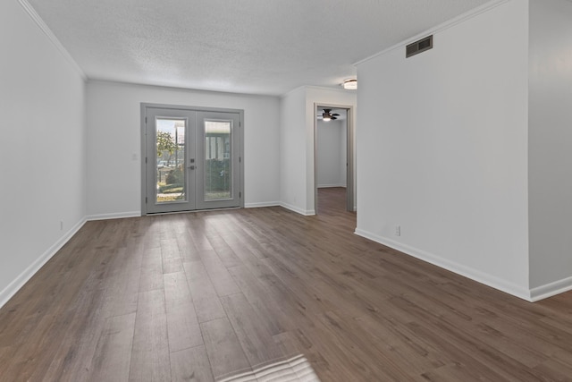 spare room with dark hardwood / wood-style flooring, ornamental molding, french doors, and a textured ceiling