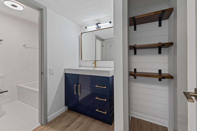 bathroom with vanity, separate shower and tub, hardwood / wood-style floors, and a textured ceiling