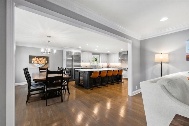 dining space featuring dark hardwood / wood-style flooring, ornamental molding, and a chandelier