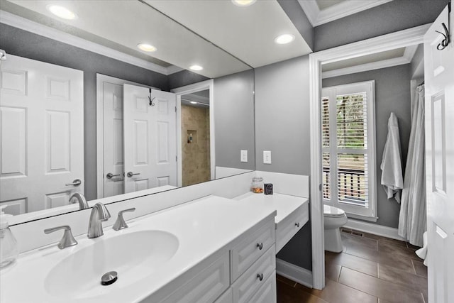 bathroom featuring tile patterned flooring, crown molding, vanity, and toilet