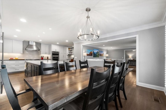 dining area featuring ornamental molding, hardwood / wood-style floors, and a chandelier