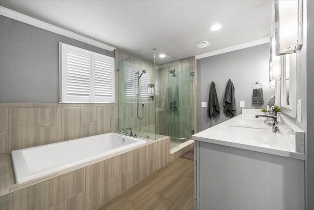 bathroom featuring vanity, crown molding, wood-type flooring, and plus walk in shower