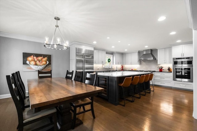 dining room with sink, crown molding, an inviting chandelier, dark hardwood / wood-style floors, and beverage cooler