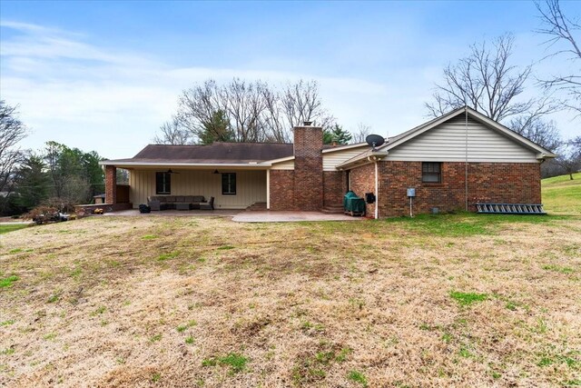 back of house with a patio and a lawn