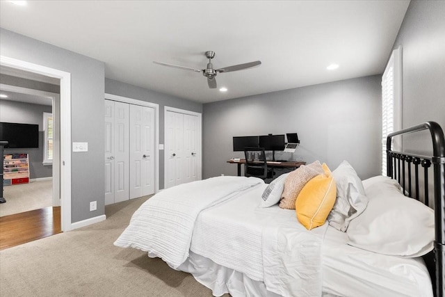 carpeted bedroom with two closets and ceiling fan