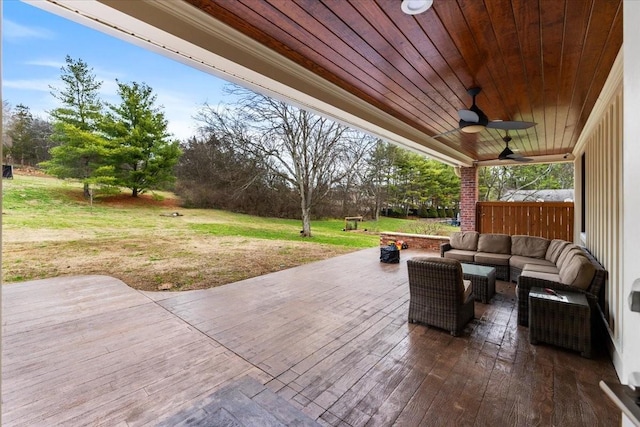 view of patio / terrace with ceiling fan and an outdoor living space with a fire pit