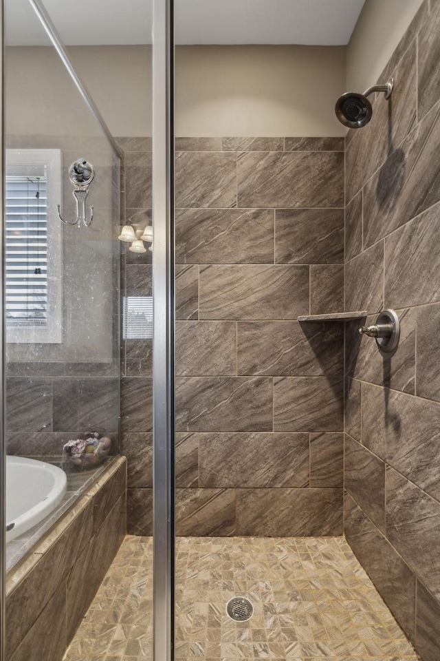 bathroom featuring shower with separate bathtub