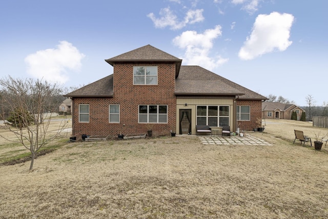 back of property featuring a lawn and a patio