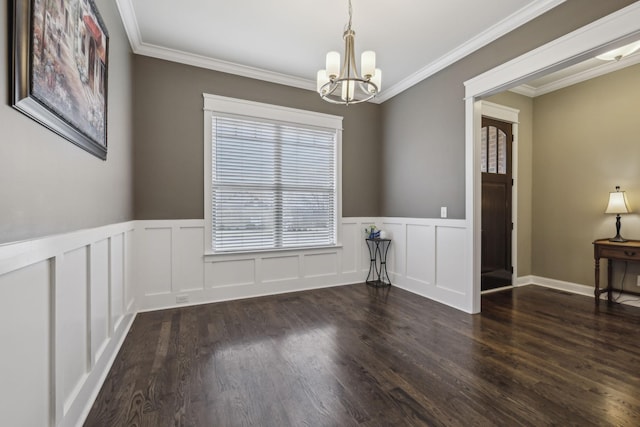 unfurnished room featuring an inviting chandelier, ornamental molding, and dark hardwood / wood-style flooring