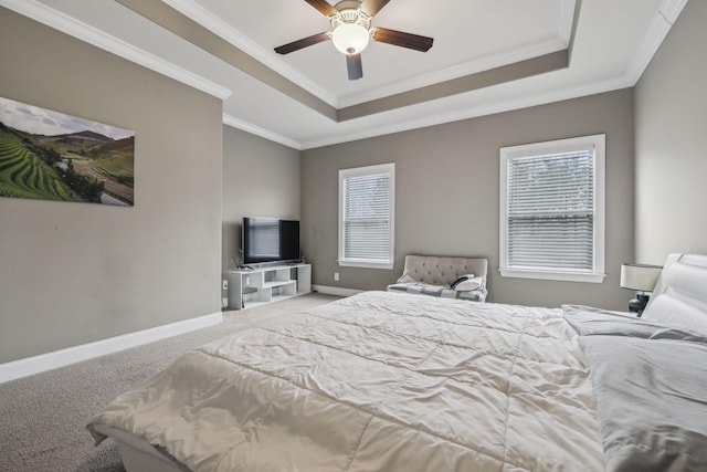 carpeted bedroom with multiple windows, a tray ceiling, and ornamental molding