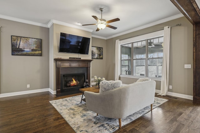 living room with crown molding, dark wood-type flooring, and ceiling fan