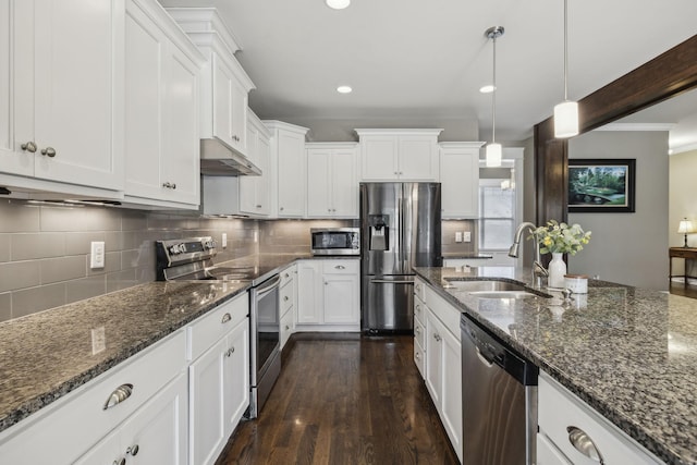 kitchen featuring sink, hanging light fixtures, stainless steel appliances, white cabinets, and dark stone counters