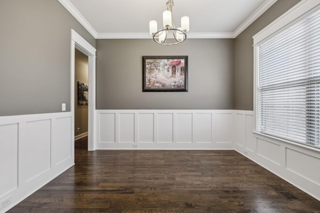 unfurnished dining area featuring dark hardwood / wood-style flooring, ornamental molding, and an inviting chandelier