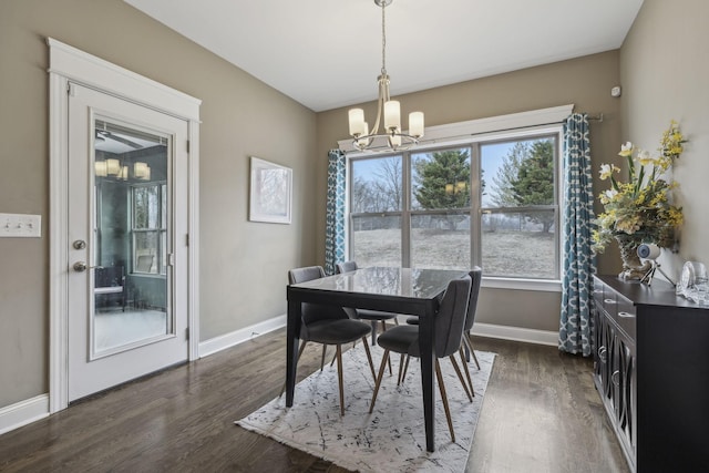 dining area with dark wood-type flooring and a notable chandelier