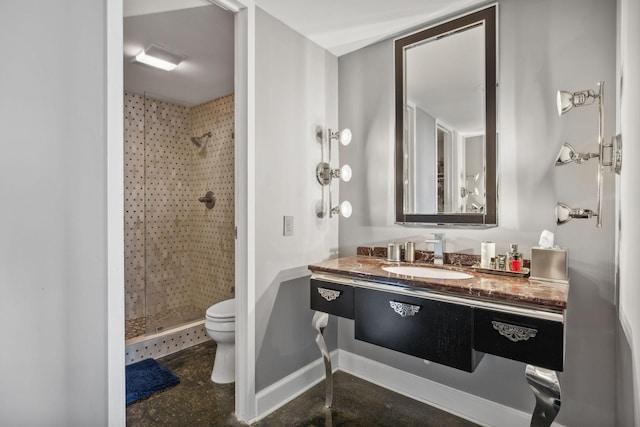 bathroom featuring vanity, toilet, and a tile shower