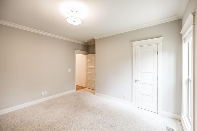 unfurnished bedroom featuring light colored carpet, crown molding, and baseboards