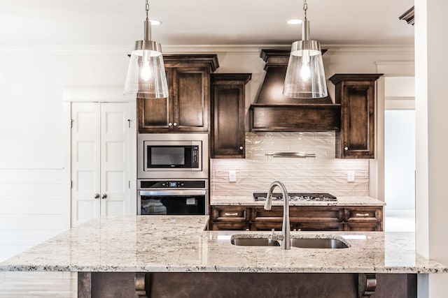 kitchen featuring dark brown cabinetry, crown molding, appliances with stainless steel finishes, and a sink