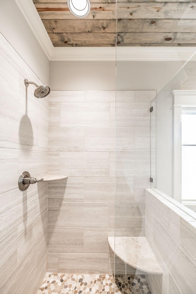 bathroom featuring ornamental molding and tiled shower