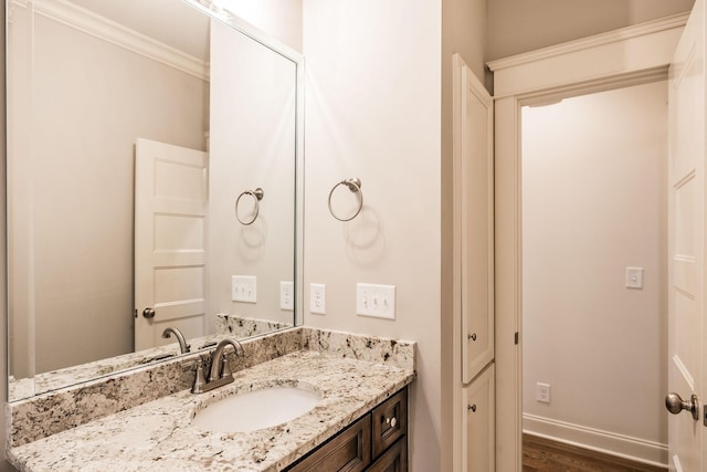 bathroom featuring baseboards, vanity, and crown molding