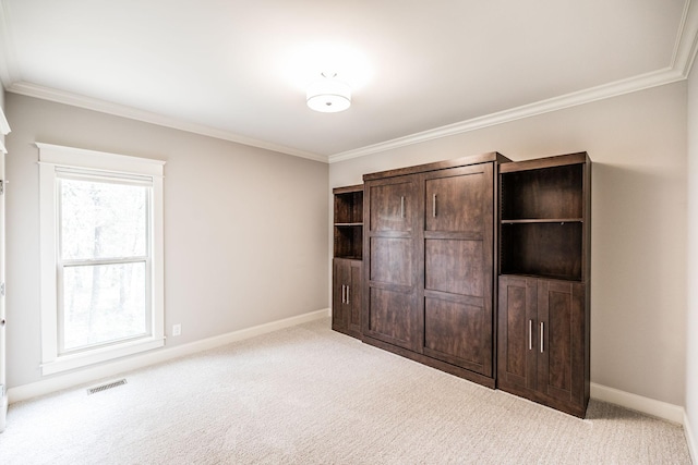 unfurnished bedroom with carpet floors, baseboards, visible vents, and ornamental molding