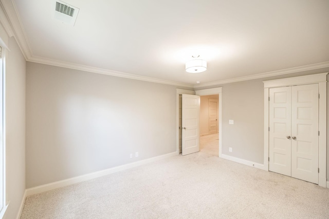 unfurnished bedroom featuring carpet floors, visible vents, baseboards, ornamental molding, and a closet