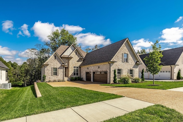 french country style house with central AC, brick siding, a shingled roof, driveway, and a front lawn