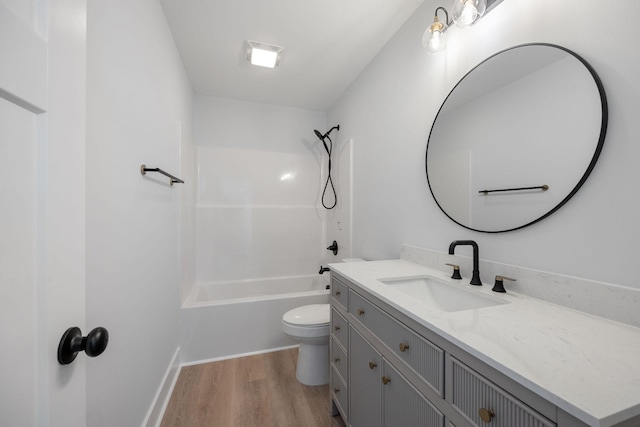 bathroom with vanity, washtub / shower combination, toilet, and wood finished floors