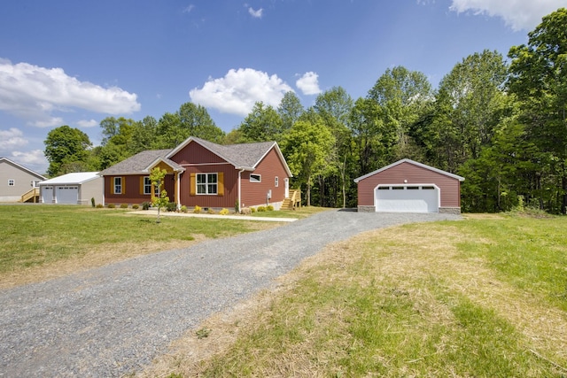 ranch-style home featuring a front lawn, an outbuilding, and a detached garage