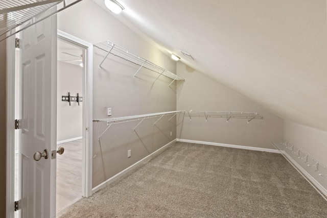 walk in closet with lofted ceiling and carpet floors