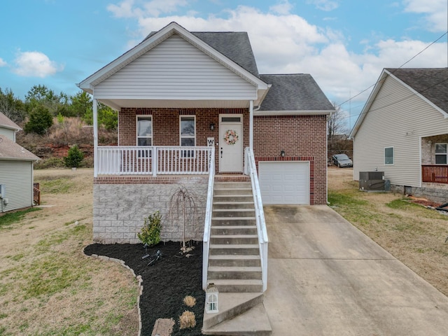 bungalow-style home featuring a garage, central AC unit, covered porch, and a front lawn