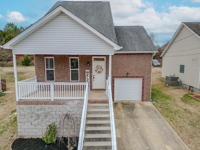 bungalow-style house featuring a garage, a front yard, cooling unit, and covered porch