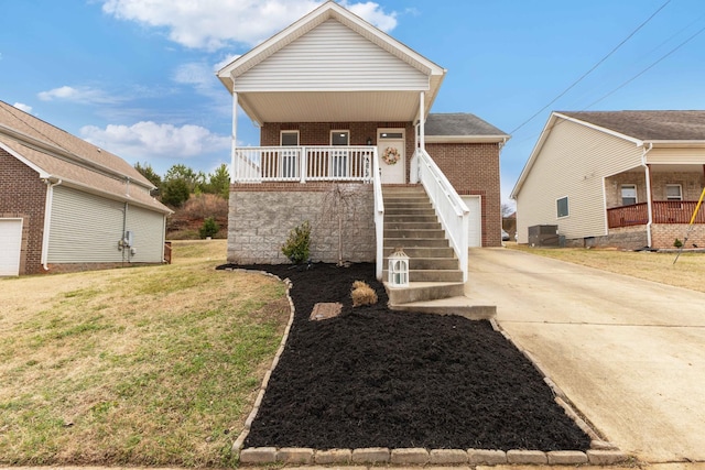 view of front of home with a garage, a front lawn, central air condition unit, and covered porch