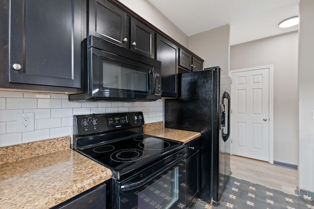 kitchen featuring light hardwood / wood-style flooring, decorative backsplash, light stone counters, and black appliances