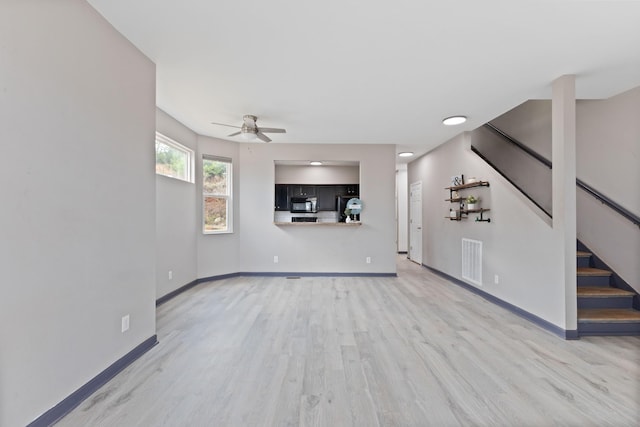 unfurnished living room with ceiling fan and light wood-type flooring