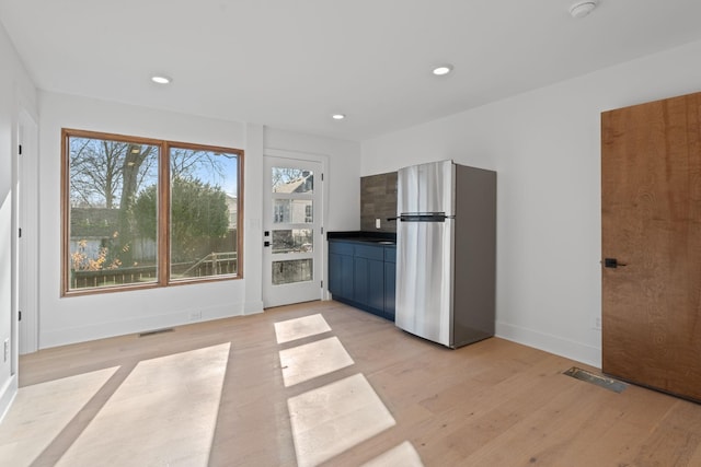 kitchen with stainless steel refrigerator and light hardwood / wood-style floors