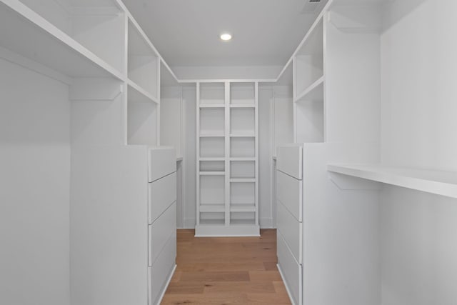 walk in closet with hardwood / wood-style flooring