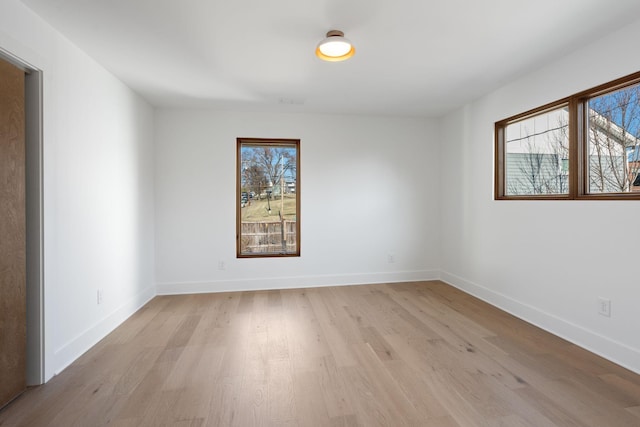 empty room with plenty of natural light and light hardwood / wood-style flooring