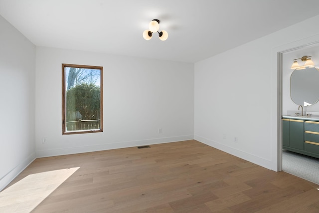 unfurnished room with sink and light wood-type flooring