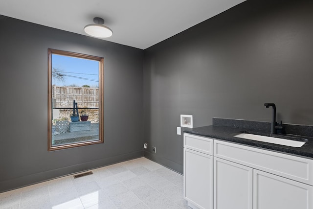 interior space with washer hookup, sink, and cabinets